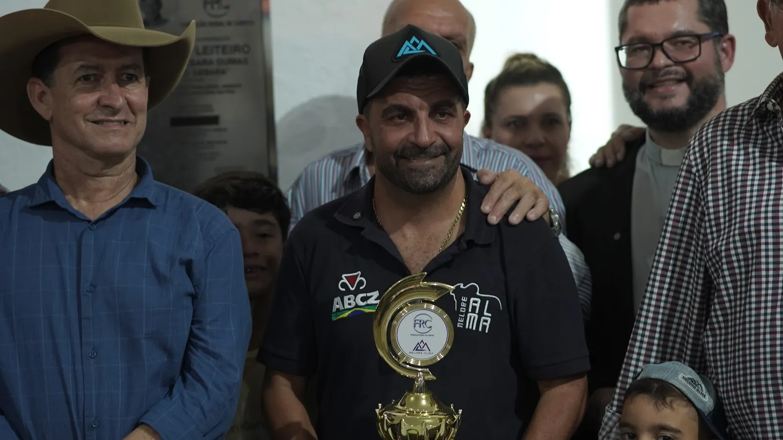 Abinho Neme com um troféu, cercado de produtores