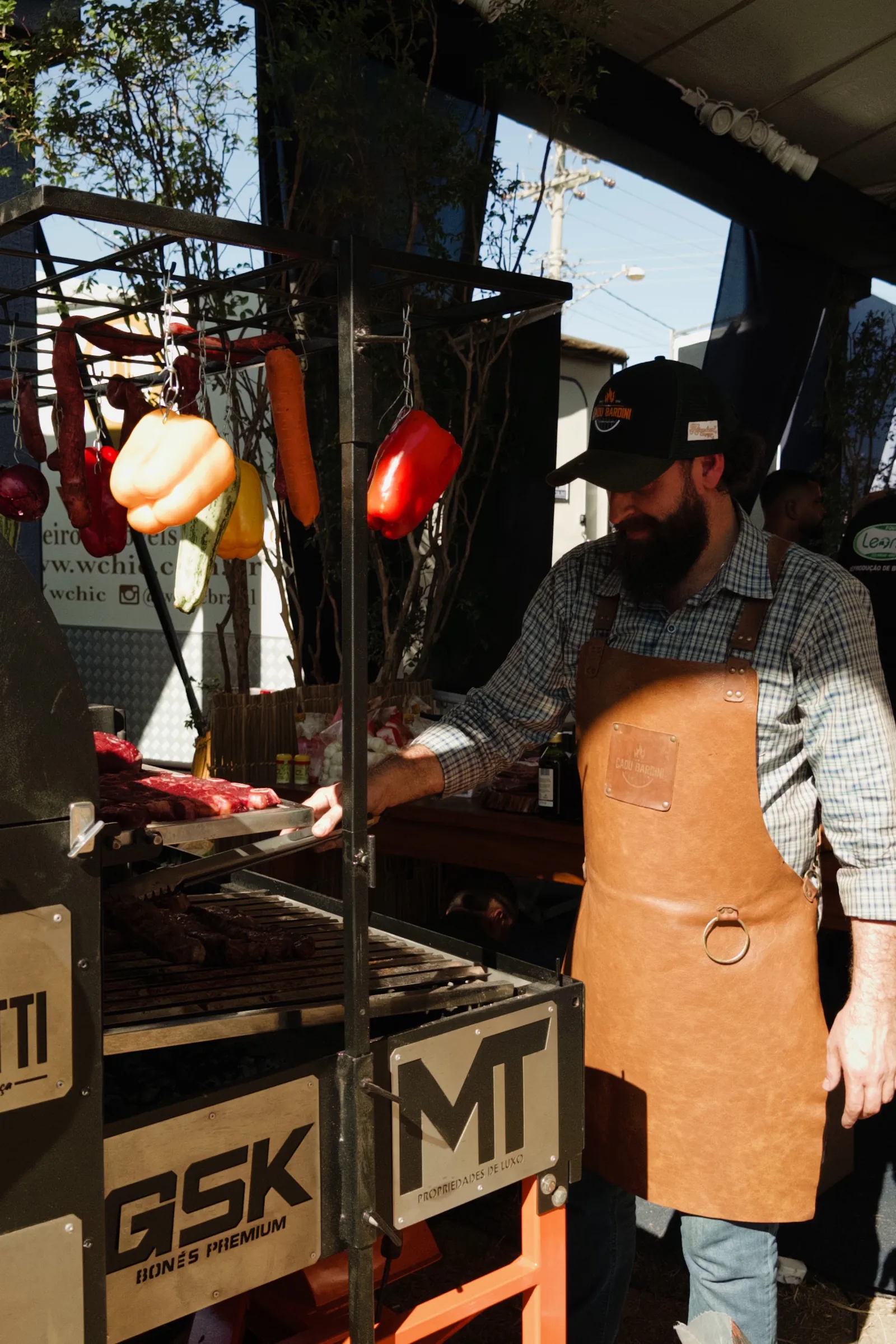 Churrasqueiro de avental de couro prepara carne num estande da 65ª ExpoAgro