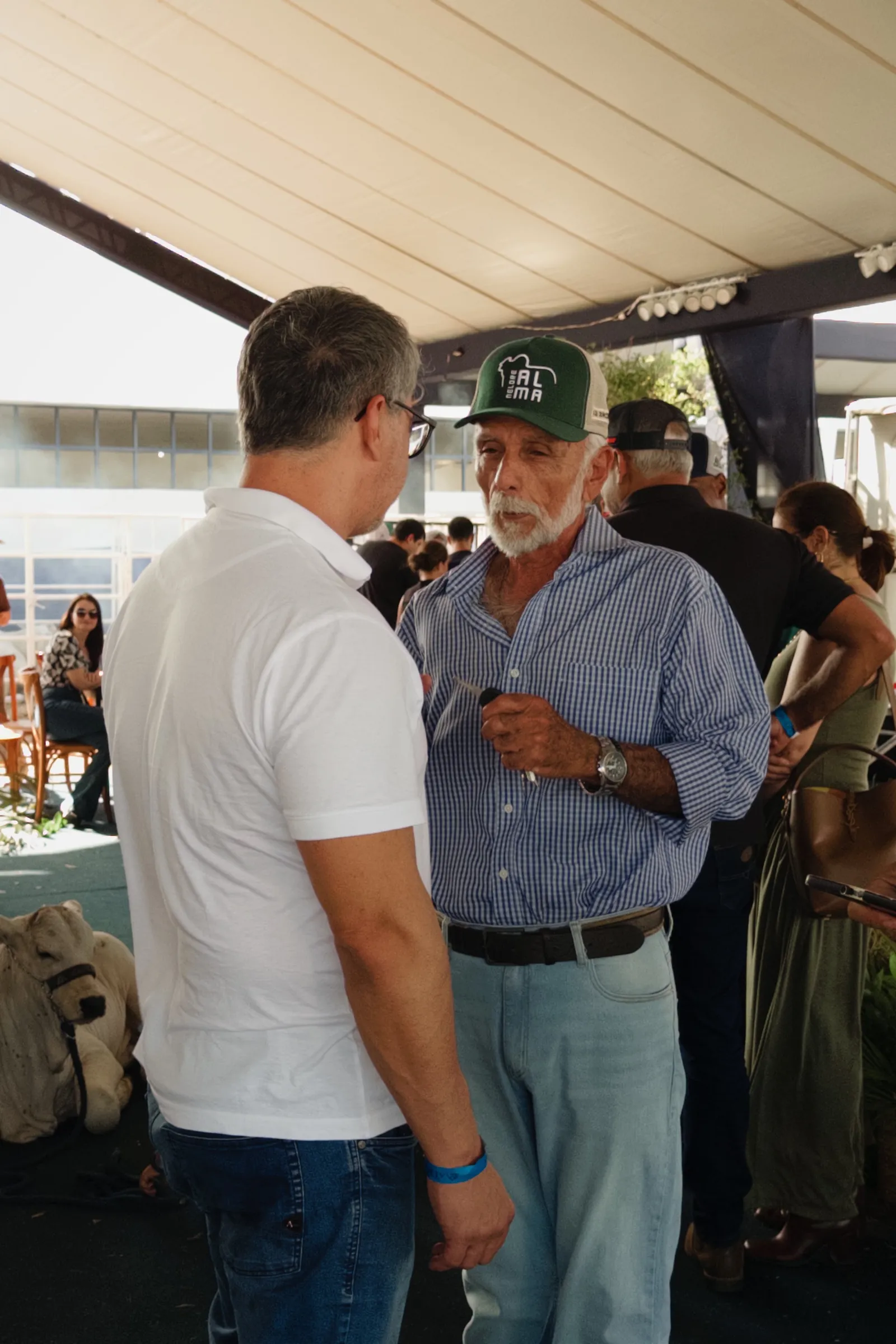 Dois criadores conversam sob a tenda de um estande na 65ª ExpoAgro