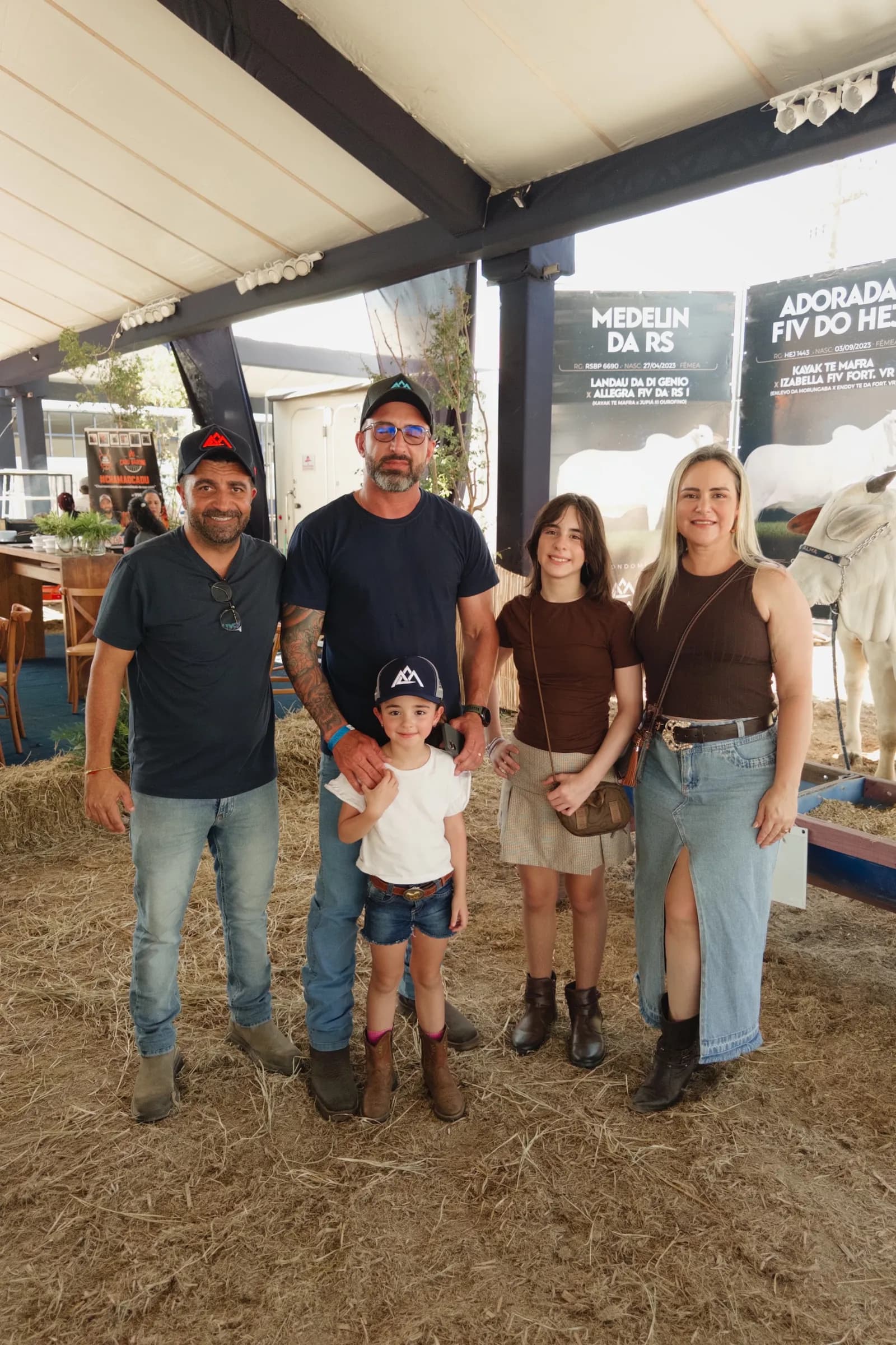 Família posa diante das baias do gado na 65ª ExpoAgro