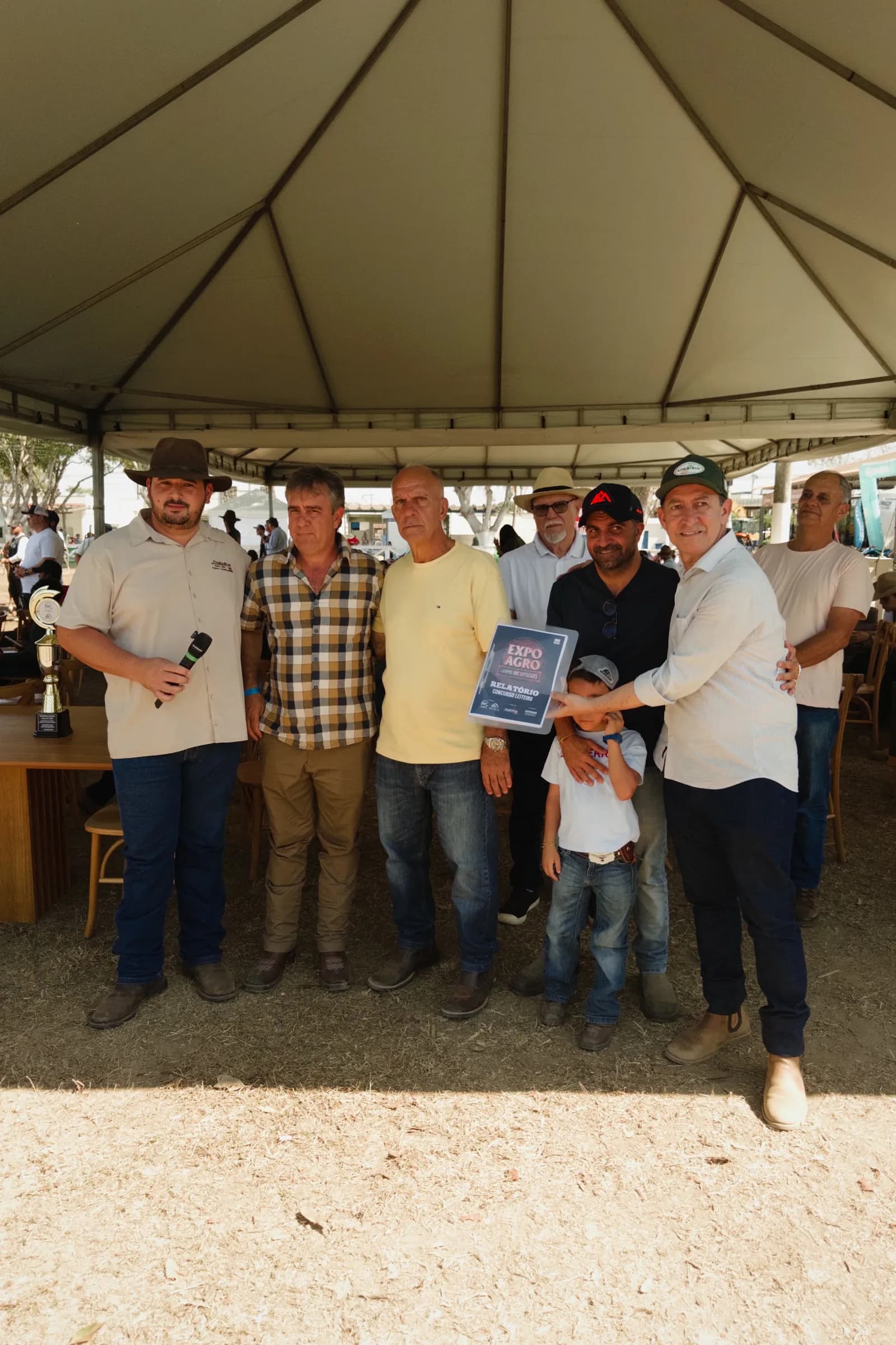 Criadores e expositores recebem uma premiação sob uma tenda na 65ª ExpoAgro