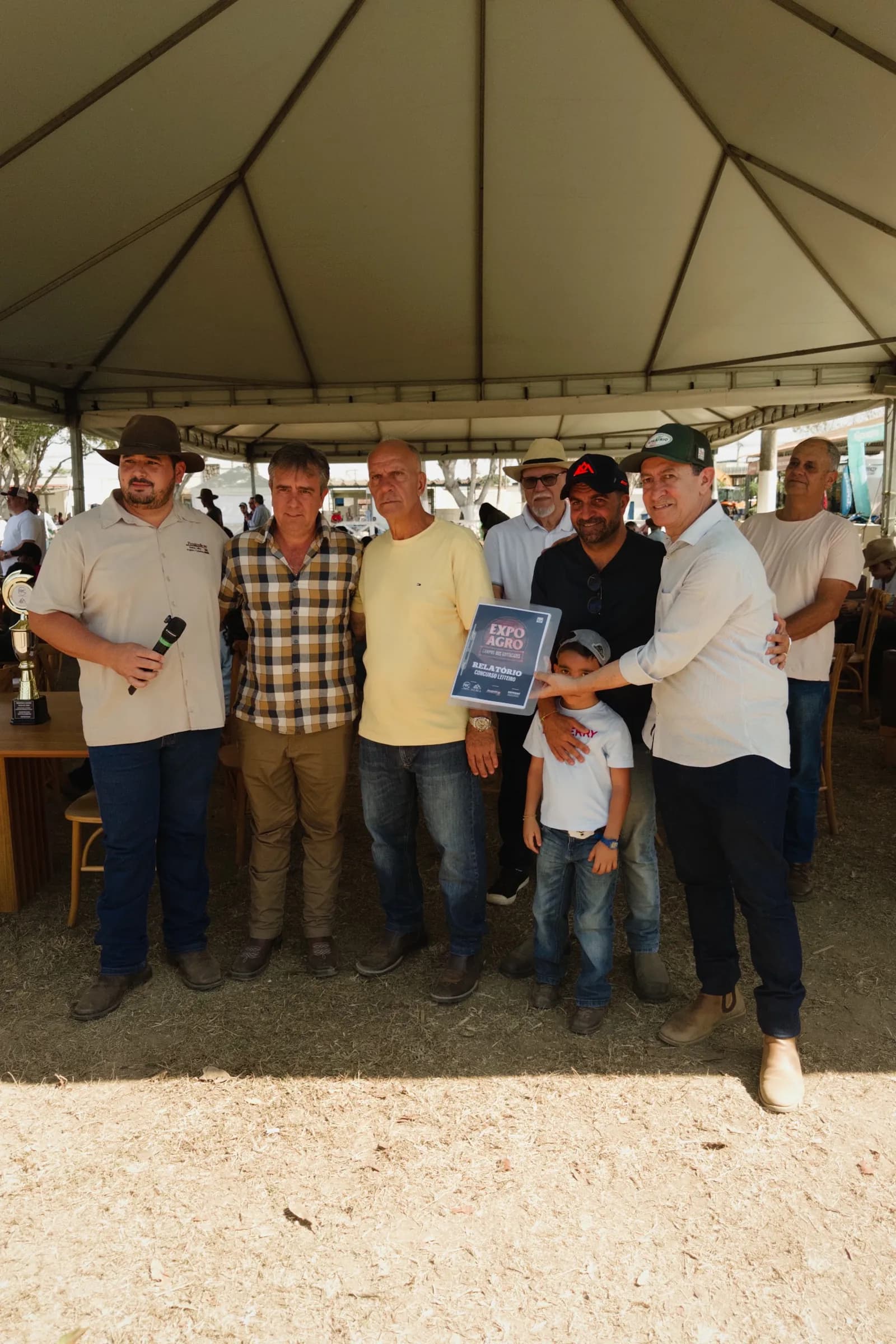 Grupo de produtores e uma família sob uma tenda no parque